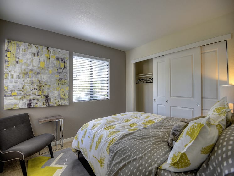 Master Bedroom with White Comforter with Golden Tree Design Pattern, Carpet, Gray Chair and Window